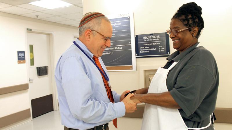 David Balto, volunteer chaplain, prays with a member of MedStar Health's hospital staff.