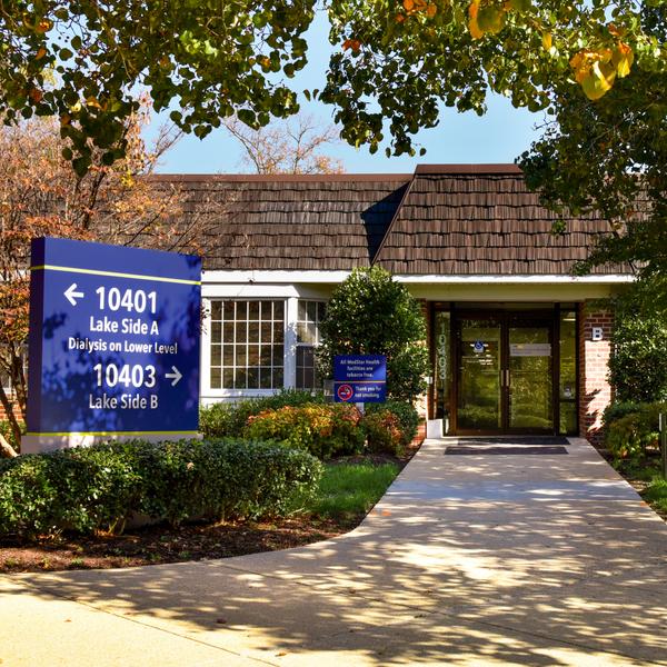 Tree-lined entrance to a brick professional building with white shutters on the campus of MedStar Southern Maryland Hospital Center