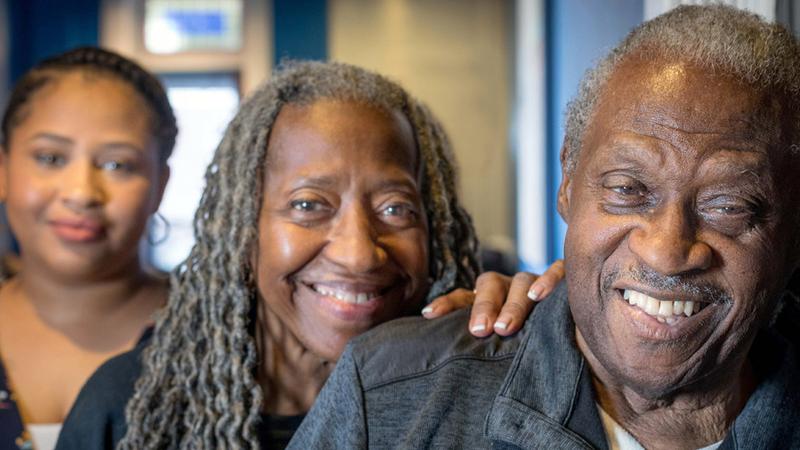 Three african american family members pose for a photo.