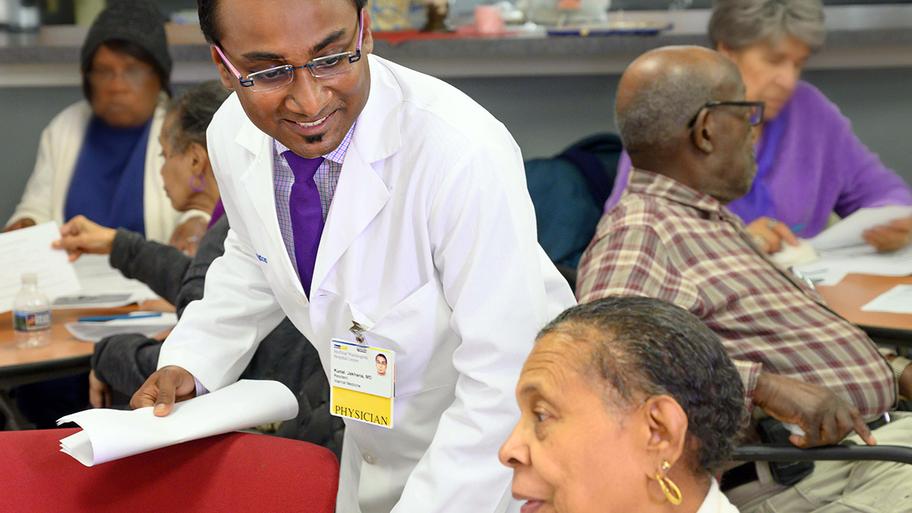 Dr. Rajus Chopra talks with a community member at a community "Ask A Healthcare Professional" event.