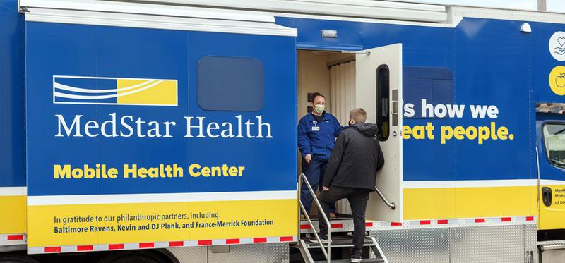 A MedStar Health provider welcomes a patient to the mobile health truck.