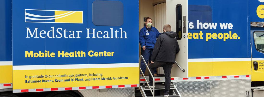 A MedStar Health provider welcomes a patient to the mobile health truck.