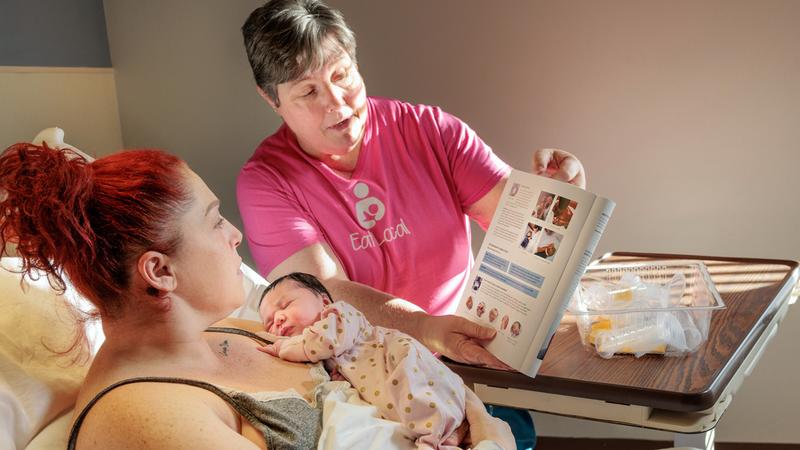 A lactation consultant talks with a mother and her newborn baby at MedStar Health.