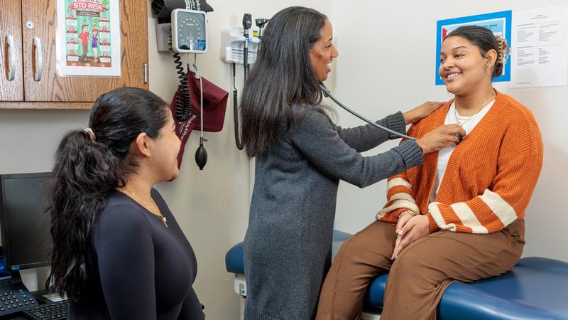 Dr. Ana Caskin listens to a patient's heart during a check-up at a school based healthcare center.