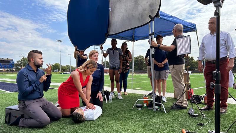 Miss District of Columbia practices CPR on a simulation mannequin during filming of MedStar Health's CPR training video.
