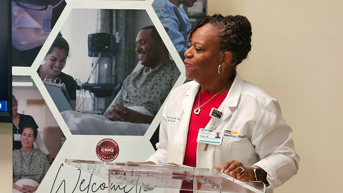 Karen Wyche speaks at a podium during a hospital based workshop at MedStar Health. 