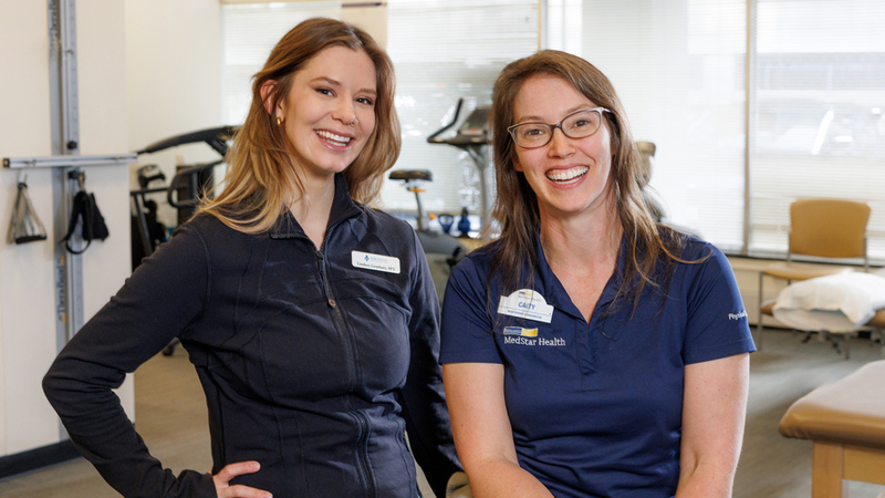 Lindsey Gearhart and Caity Tompkins in a physical therapy gym.