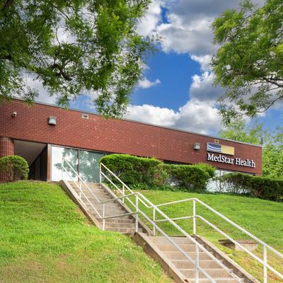 A red brick and glass office building at the top of a hill is home to MedStar Health Primary Care at Kirk Avenue in Baltimore, MD.