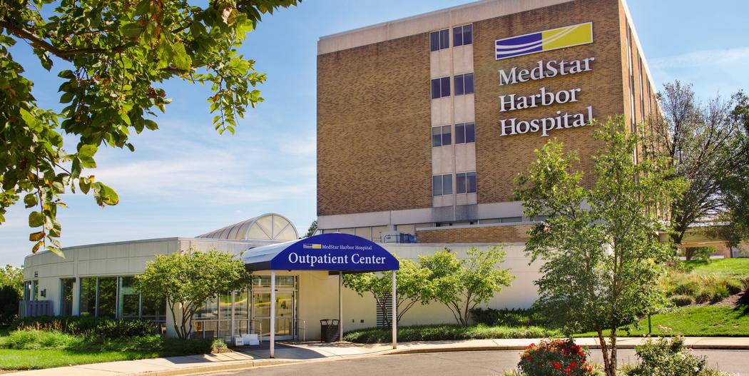 The lower entrance to the Outpatient Center at MedStar Harbor Hospital is on the side of the building and has a blue awning