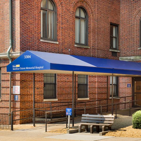 MedStar Health Neuroscience at Baltimore is located in a large brick building with a long entry way covered by a blue awning. The street number and MedStar Health logo are on the front of the awning.
