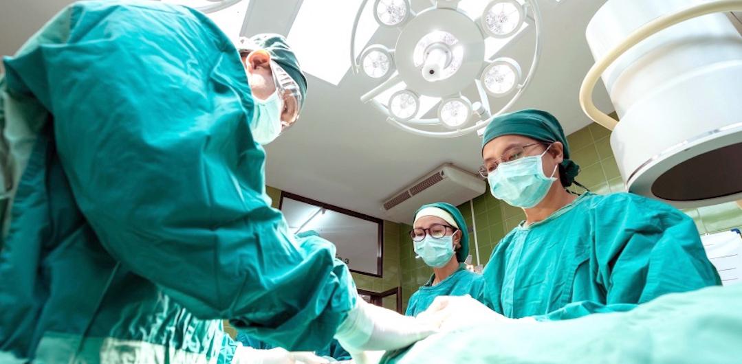 三个外科医生在病人在手术室工作博客说明神经瘤的研究。