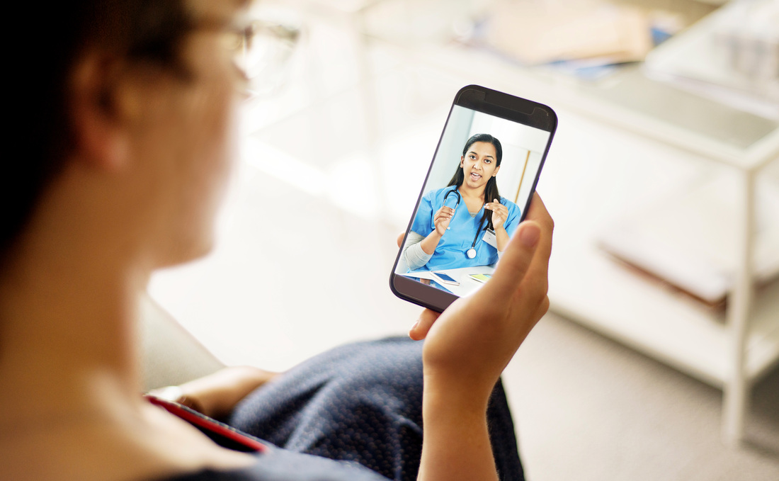 A woman talks with a healthcare provider during a telehealth appointment.