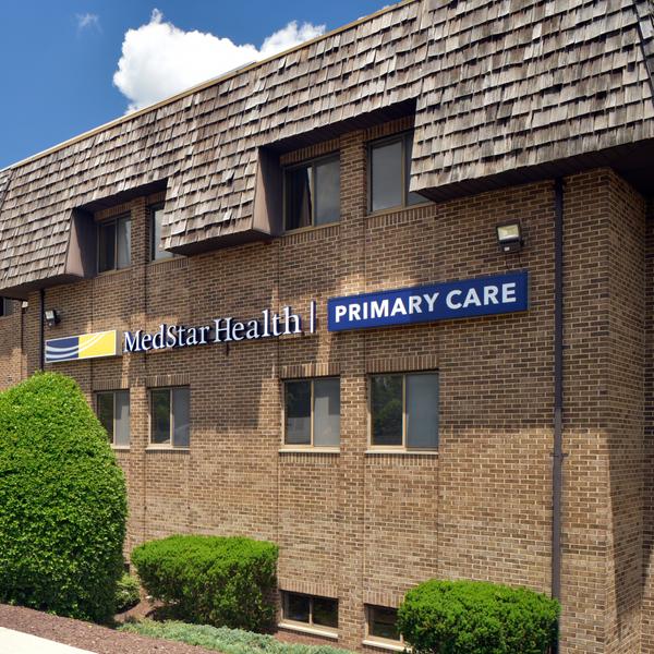 A 2-story brick building with a red metal roof is the location for MedStar Health Primary Care at Upper Marlboro, Maryland.