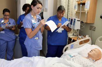 A group of nurses participates in simulation training.