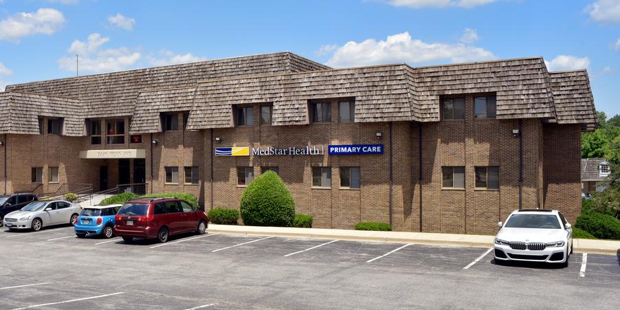 A 2-story brick building with a red metal roof is the location for MedStar Health Primary Care at Upper Marlboro, Maryland.