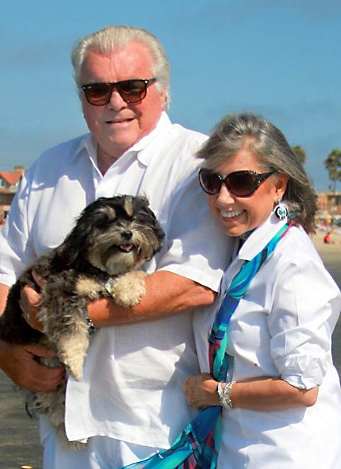 Bill and Carolyn Bivens pose for a photo outdoors with their dog.