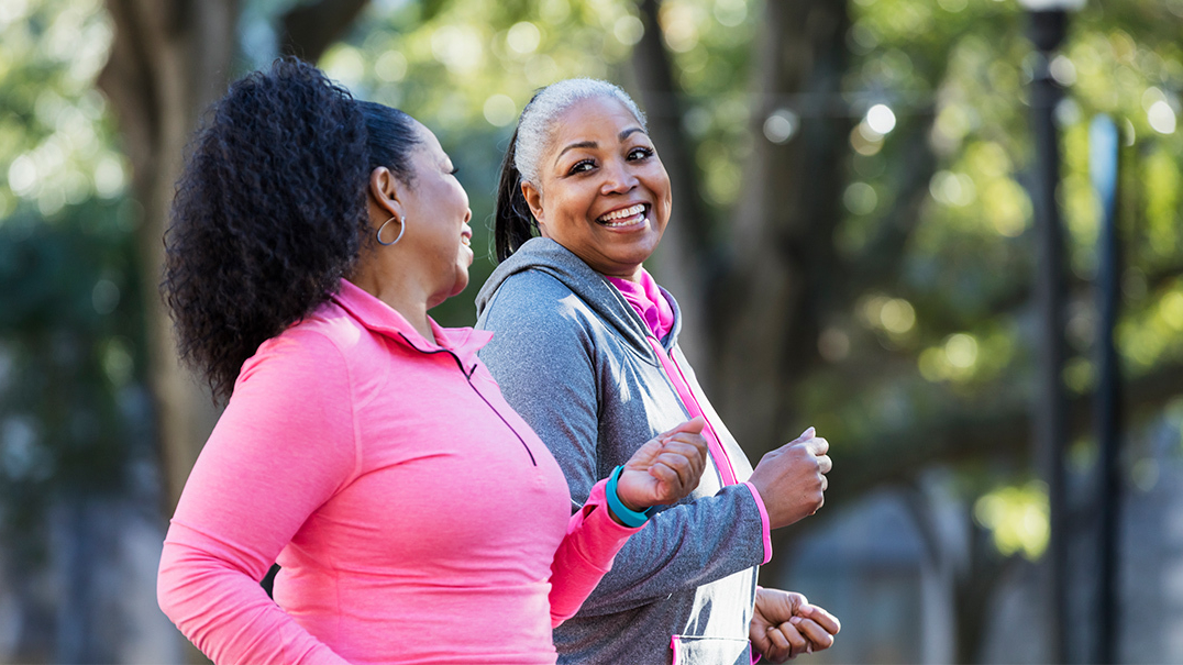 Two women walk outdoors for exercise.