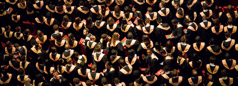 Graduates at a commencement ceremony photographed from above.