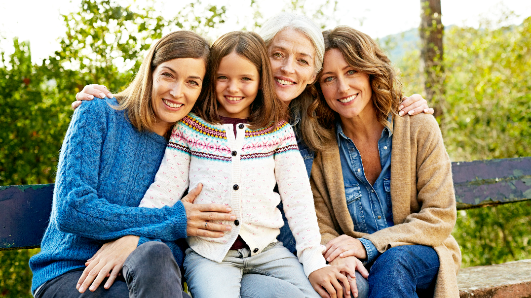 A multigenerational group of women sit outdoors