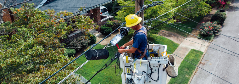 A lineman works on electrical lines from a bucket truck.