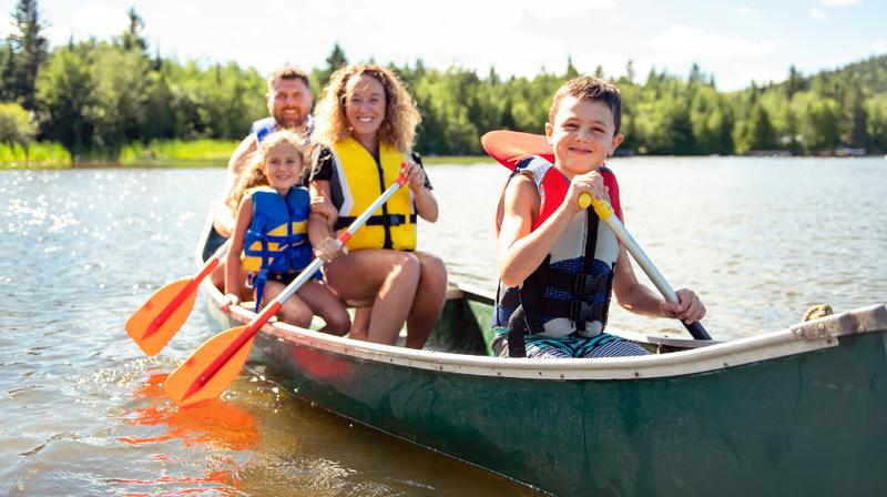 A family has fun kayaking together on a lake outdoors.