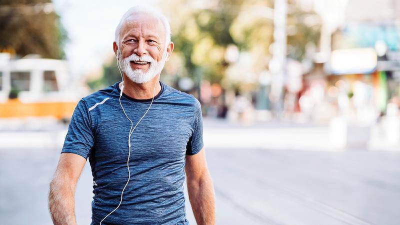 A senior man walks outdoors for exercise.