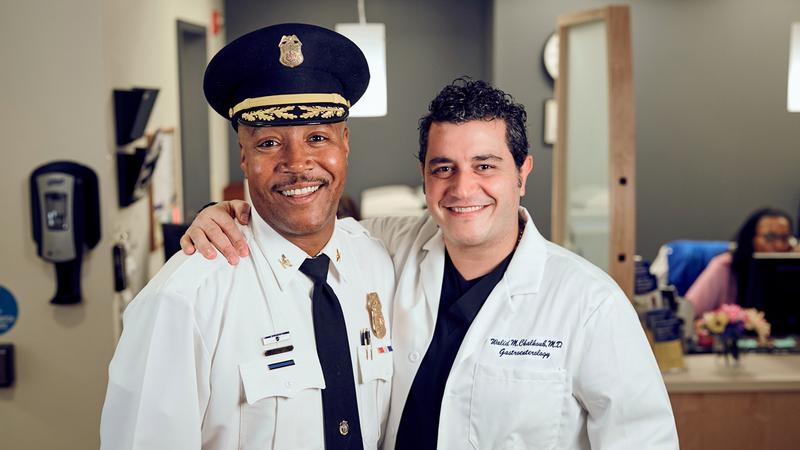 上万宝路警察局长Calvin Washington站在MedStar华盛顿医院中心的大厅里，与MedStar Health的Walid Chalhoub医生合影。