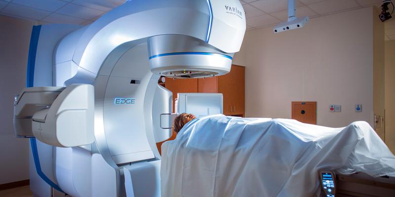 一个病人躺在EDGE立体放射手术机的桌子上。