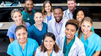 A diverse group of healthcare professionals poses for a group photo. The photo is taken from a high angle.