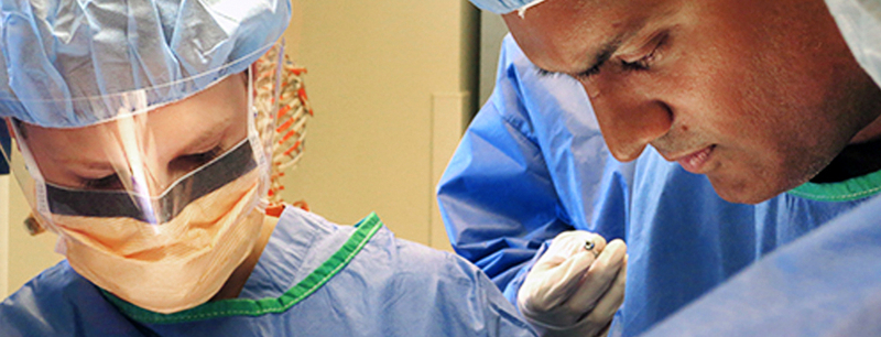 Close up photo of 2 surgeons in an operating room.