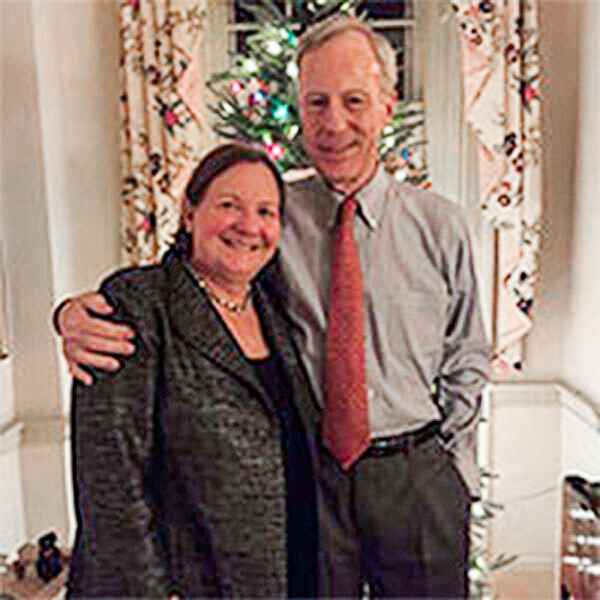 Jeffery Ferrill stands with his arm around his wife and they both smile at the camera.