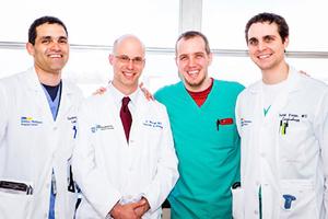 A group of 4 male MedStar medical professionals stand together and smile for the camera. 