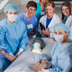 A group of medical students pose for a photo around a simulation mannequin in a simulation lab.