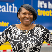 Shannon Holder, MedStar Health mobile healthcare team member, poses for a photo in front of the mobile healthcare center truck.