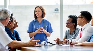 A nurse talks during a meeting of healthcare professionals