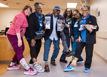 Jeffrey Myers poses for a photo with nurses at MedStar Health. They are wearing colorful socks.