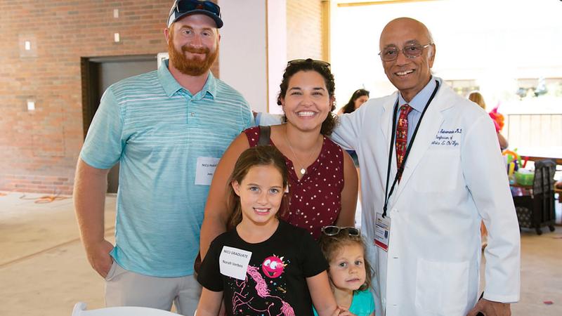 Dr. Siva poses for a photo with a family at MedStar Georgetown University Hospital's NICU reunion event.