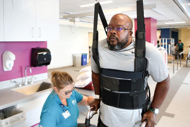 A patient walks with the aid of a Zero G assistance device during a session with a physical therapy rehabilitation specialist at MedStar Good Samaritan Hospital's inpatient rehab center.