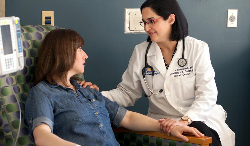 Dr Mahsa Mohebtash talks with a patient undergoing cancer treatment in a clinical setting.
