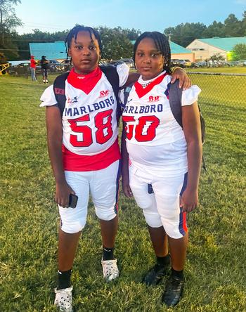 Malcom Gantt #58 on the football field with a fellow player.