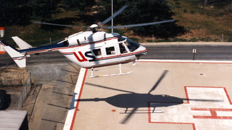 Historic photo of a white helicopter landing on a rooftop helicopter pad.