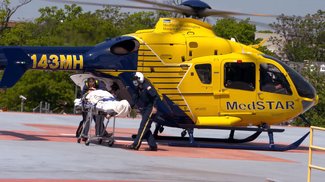 The MedStar Health helicopter crew unloads a patient on a hospital helipad.