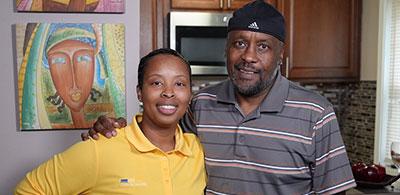 Mia and Jeff pose for a photo in a home kitchen. 