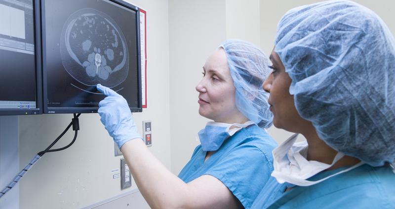 Two female medical professionals look at diagnostic imaging of the brain