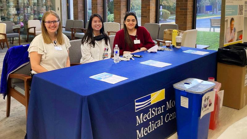 Three MedStar pharmacists work at an event to take back unused drugs and pharmaceutical paraphenalia for safe disposal.