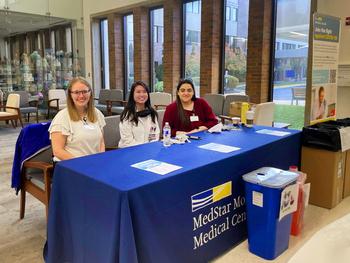 Three MedStar pharmacists work at an event to take back unused drugs and pharmaceutical paraphenalia for safe disposal.