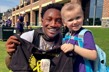 Pediatric cancer patient, Sunny, poses for a photo with her favorite Ravens player Zay Flowers at training camp.