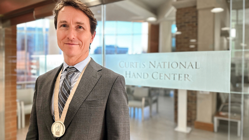 Dr. James Higgins, MedStar Health hand surgeon, wears the prestigious 2024 Andrew J. Weiland Medal awarded to him by the American Society for Surgery of the Hand (ASSH).