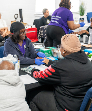 A MedStar Health associate holds the hand of a community member at a community health event.