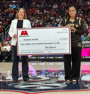 Angela D. Thomas, DrPH, MPH, MBA and Aimee Danielson, PhD accept a donation check for $1.1M from Monumental Sports & Entertainment in support of providing specialized care to birthing mothers, infants, and children of all ages in Washington, D.C.